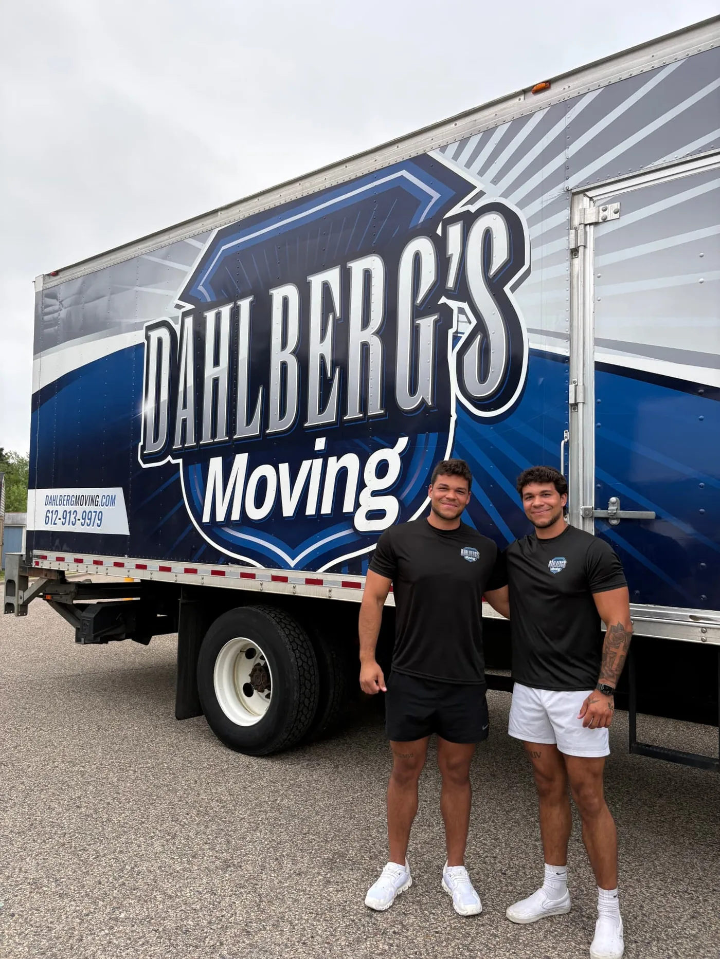 Two Dahlberg's Moving team members beside a Dahlberg's Moving box truck